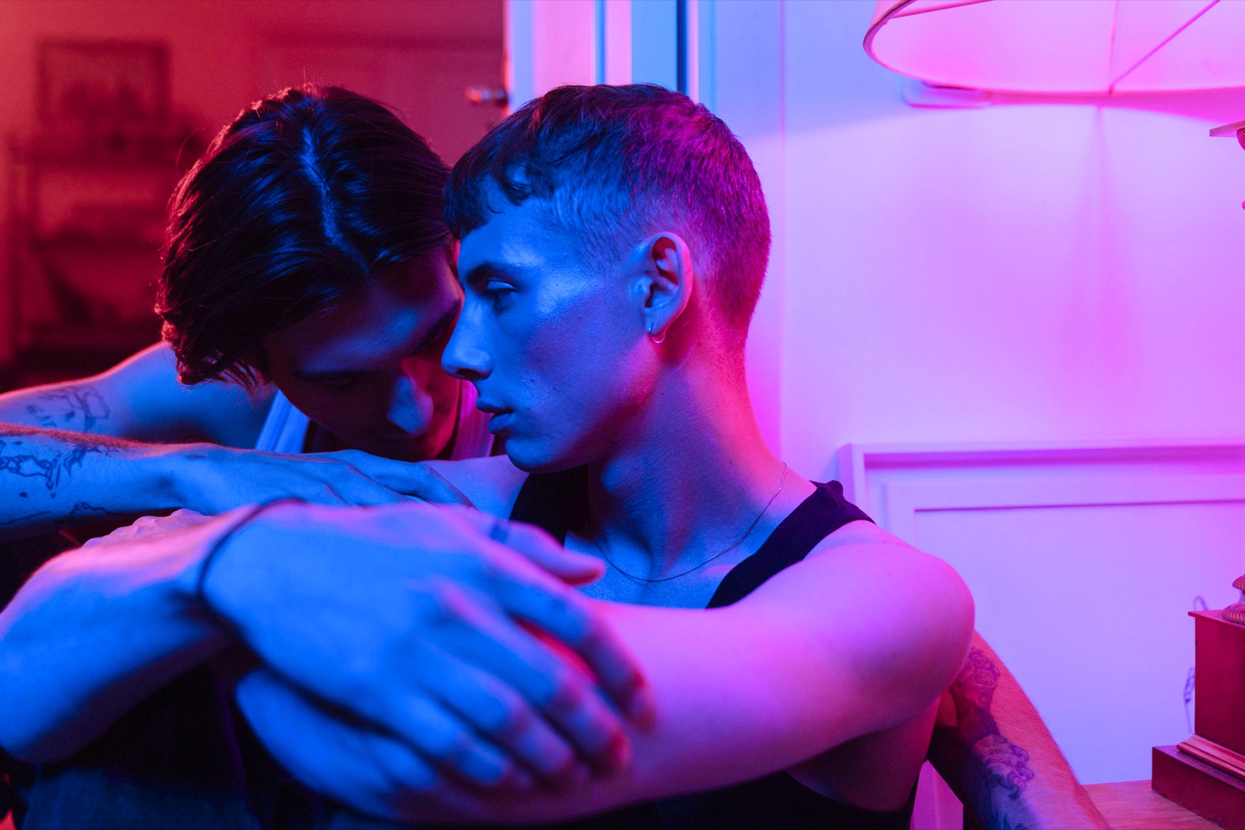 Queer male couple in pink and blue neon light